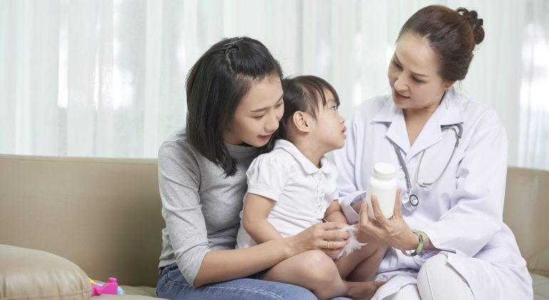Visiting pediatrician Pediatrician showing prescribed medicine mother and her little daughter