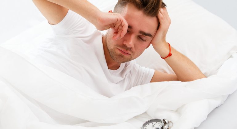 Young man in the bed is insomnia a symptom of anything