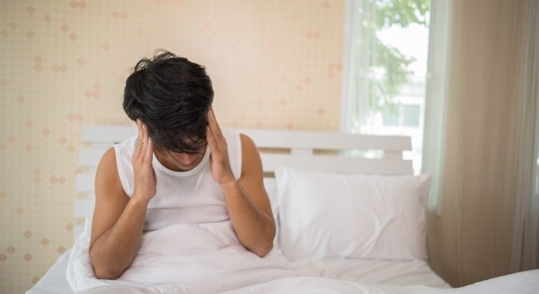 Male with lack of sleep in the bed sleeping-pills
